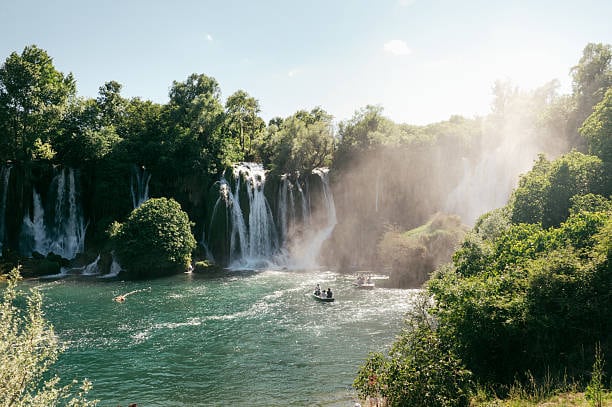 Kravice waterfalls with a small boat on the pool below