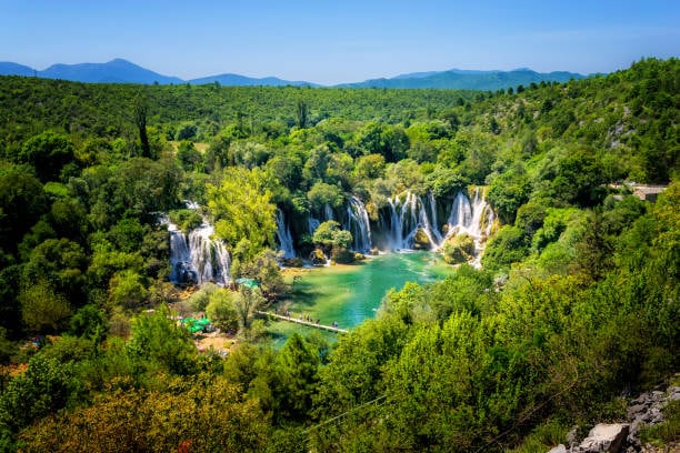 Kravice waterfalls in a green semicircle of forest
