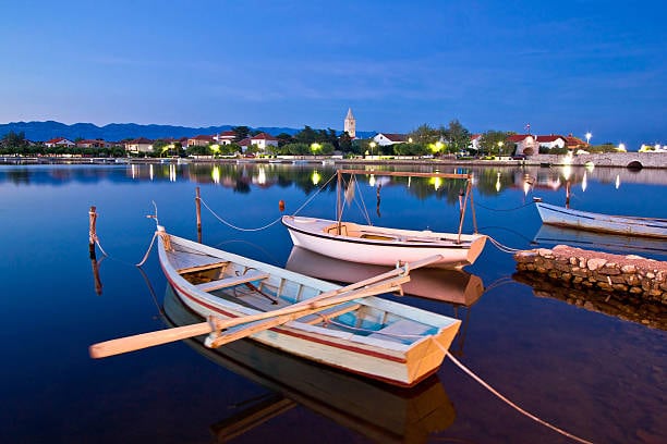 Wooden boats on the calm lagoon at Nin at dusk