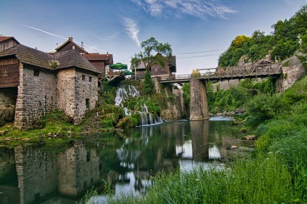 Old watermill houses and a bridge over the water in Rastoke