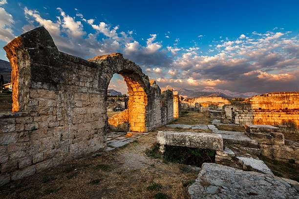 Stone arch among the ruins of Salona at sunset
