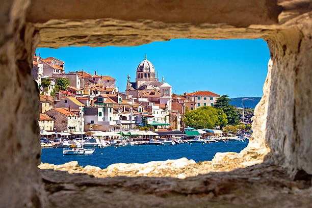 Šibenik old town and the cathedral dome seen through a stone window