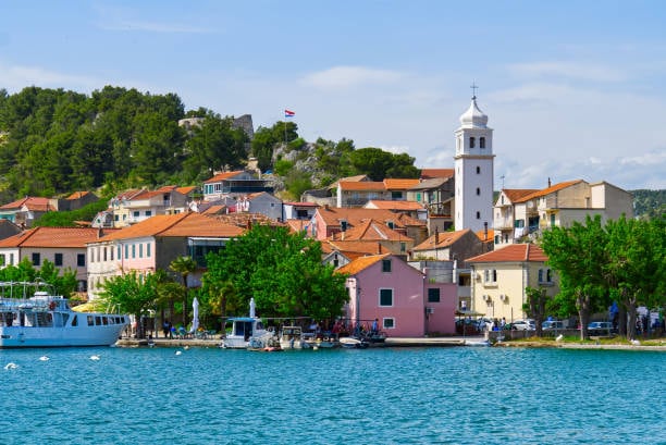 Skradin waterfront with boats and the church bell tower